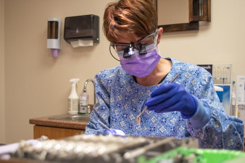 dental professional performing a preventive check for her patient