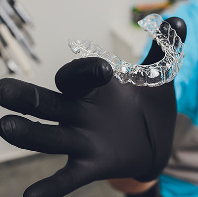 dentist holding Invisalign teeth tray