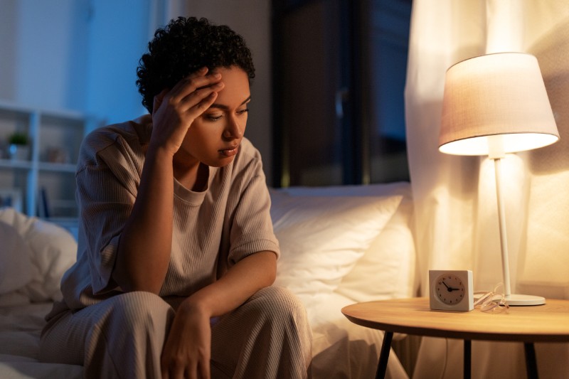 person sitting up in bed, unable to sleep