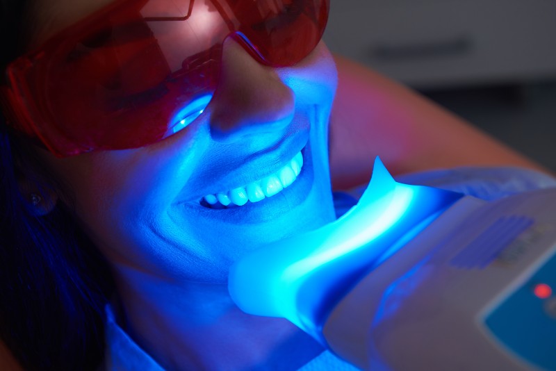person whitening their teeth with zoom whitening